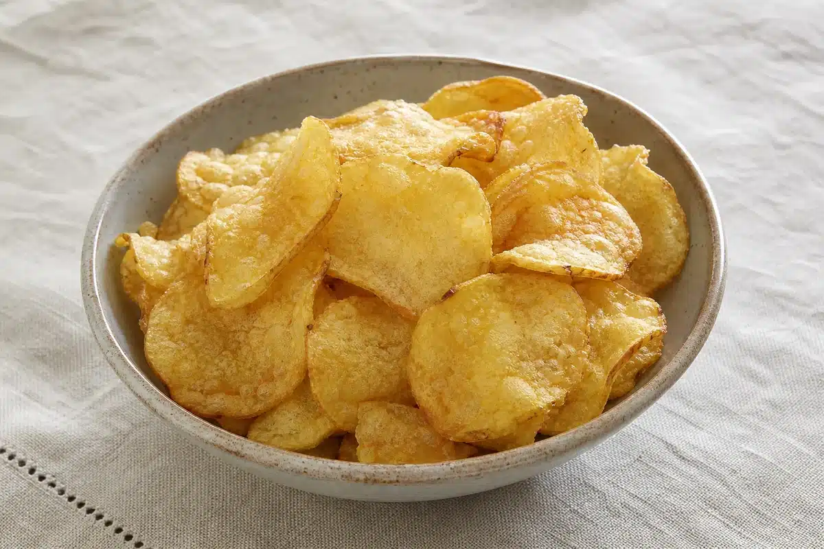 Golden kettle-cooked potato chips in a serving bowl | EpicureDelight