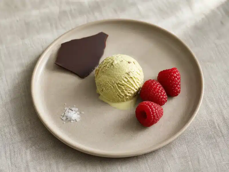 Pistachio ice cream with raspberries dark chocolate and flaky salt