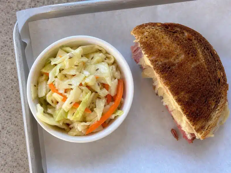 Vinegar cabbage slaw beside a Reuben sandwich - best Reuben side | EpicureDelight