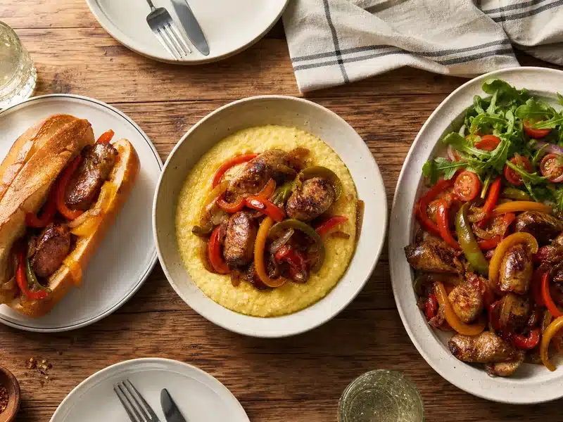 Sausage and peppers in a roll, over polenta, and on a platter | EpicureDelight