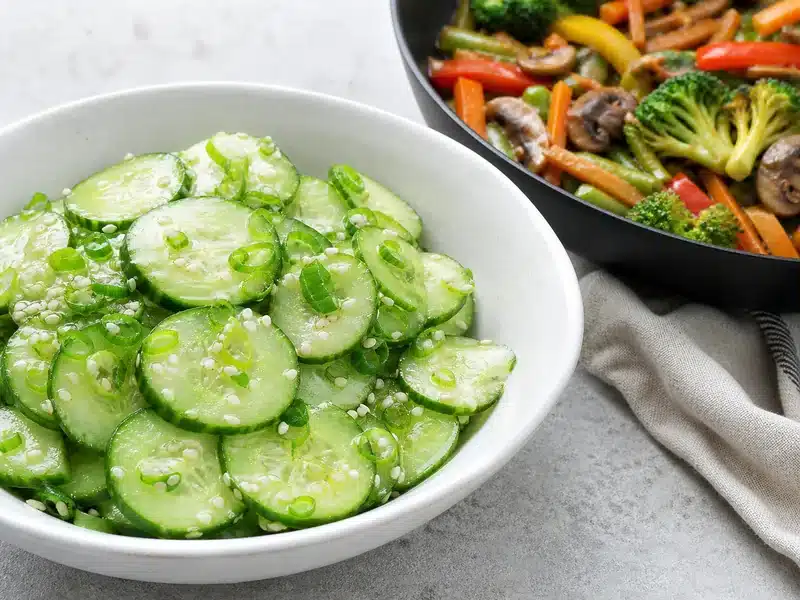 Cucumber sesame salad beside vegetable stir-fry - stir-fry side dish | EpicureDelight
