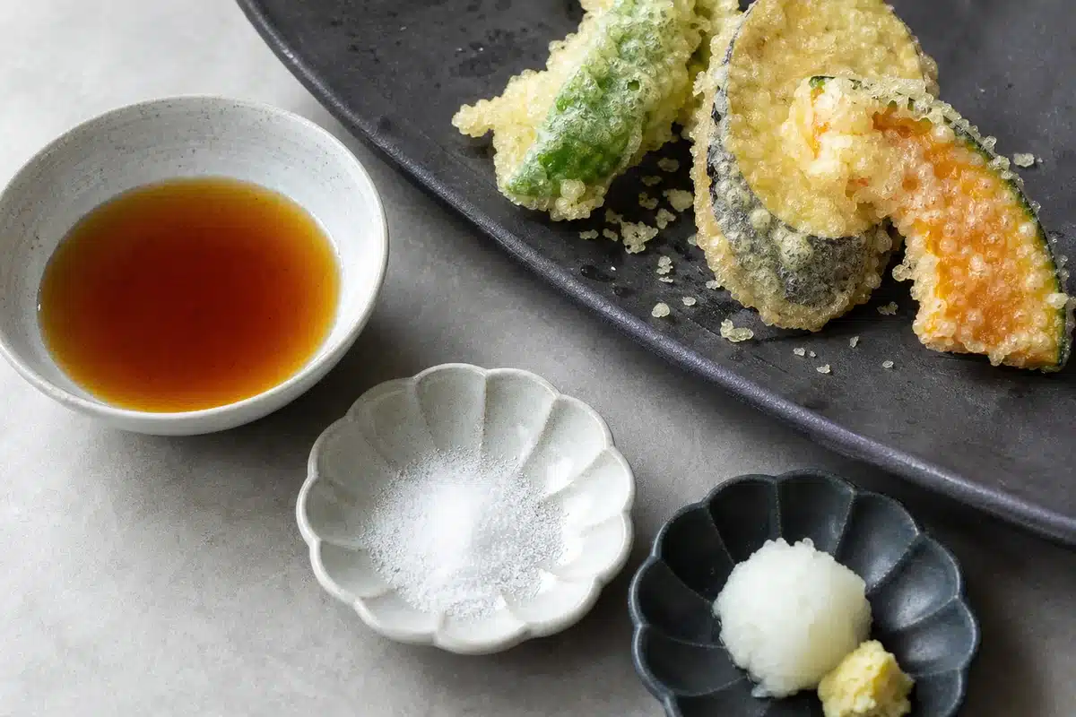 Tentsuyu, salt, and grated daikon beside crisp vegetable tempura - tempura dipping setup | EpicureDelight